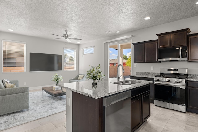 392 Pecos Loop SE, Rio Rancho, NM 87124 - kitchen featuring stainless steel appliances, a sink, open floor plan, ceiling fan, and light stone countertops
