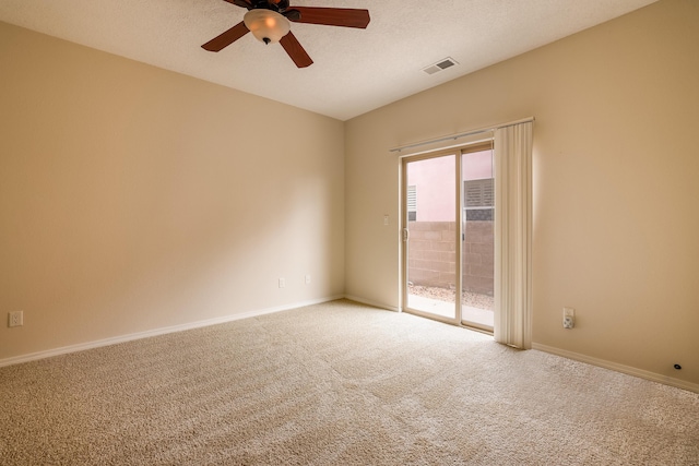 carpeted empty room with a ceiling fan, visible vents, a textured ceiling, and baseboards