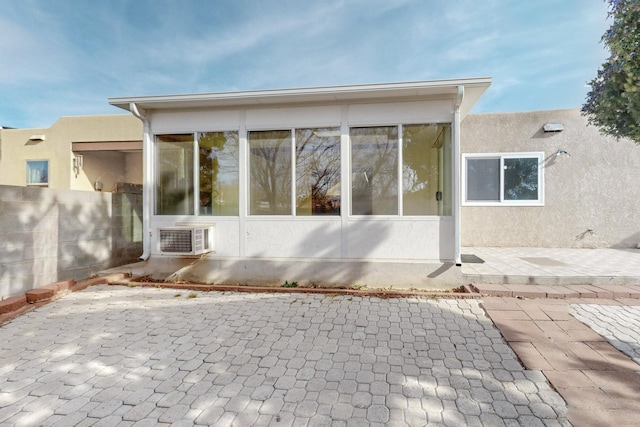 exterior space with a patio, cooling unit, a sunroom, and stucco siding