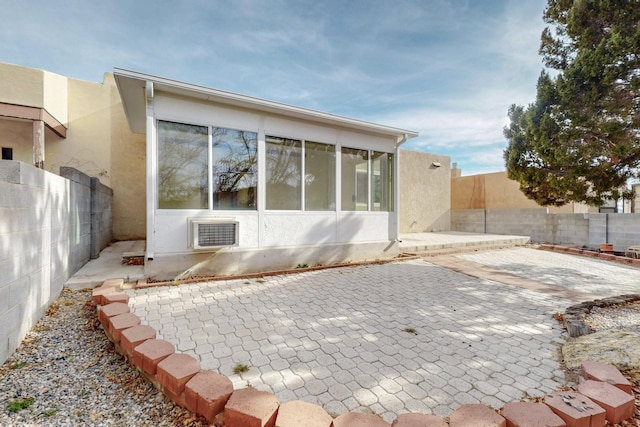 rear view of property with a patio area, a fenced backyard, visible vents, and stucco siding