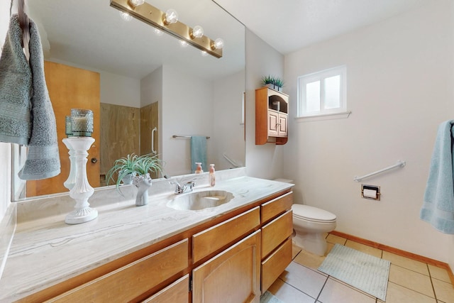 full bathroom featuring toilet, vanity, baseboards, and tile patterned floors