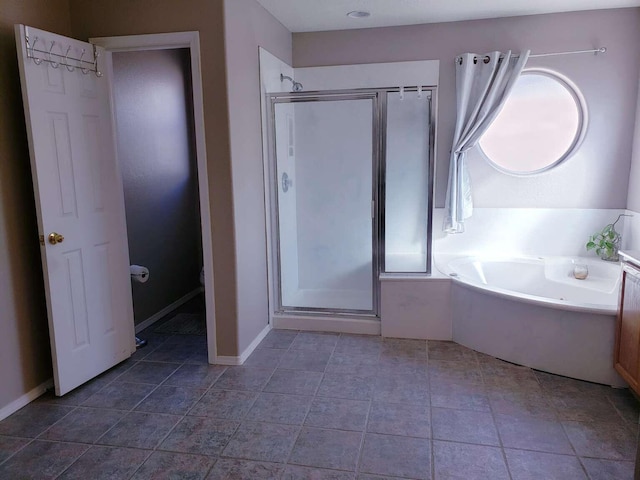 full bathroom featuring a garden tub, a shower stall, baseboards, and tile patterned flooring