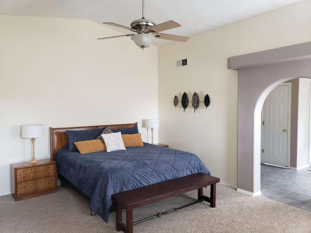 bedroom featuring visible vents, arched walkways, vaulted ceiling, and carpet flooring