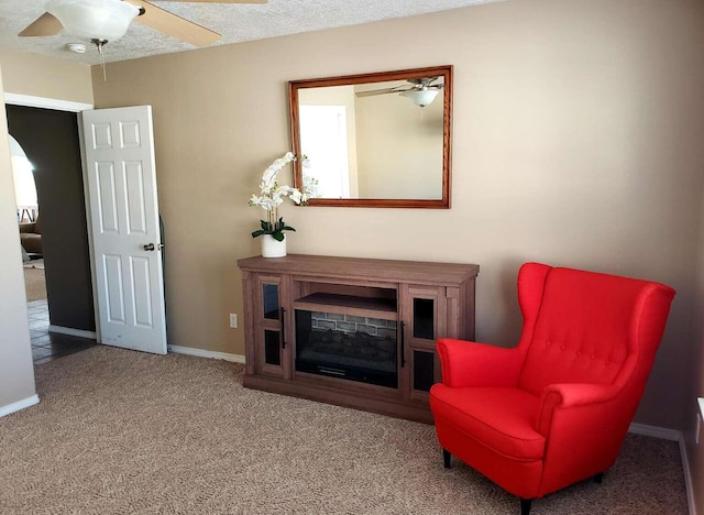 sitting room with carpet flooring, ceiling fan, a textured ceiling, and baseboards