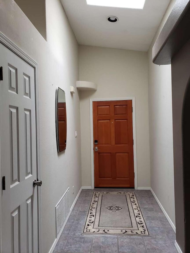 foyer entrance with visible vents and baseboards