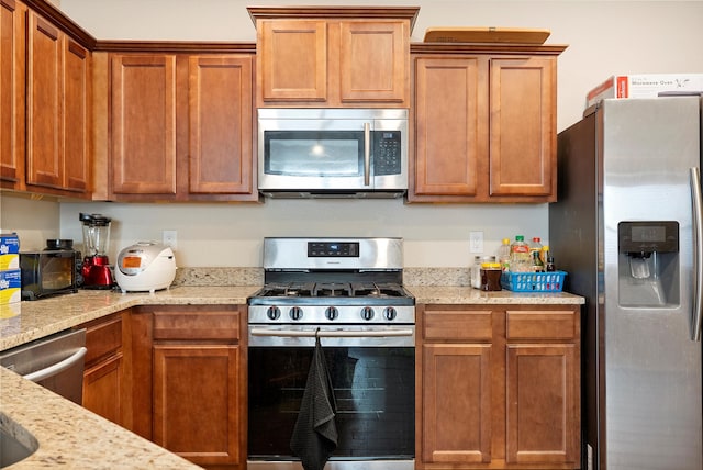 1735 Garden Way SW, Albuquerque, NM 87105 - kitchen featuring appliances with stainless steel finishes, light stone counters, and brown cabinets