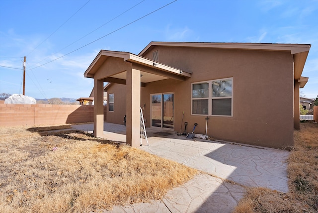 1735 Garden Way SW, Albuquerque, NM 87105 - back of property featuring stucco siding, fence, and a patio