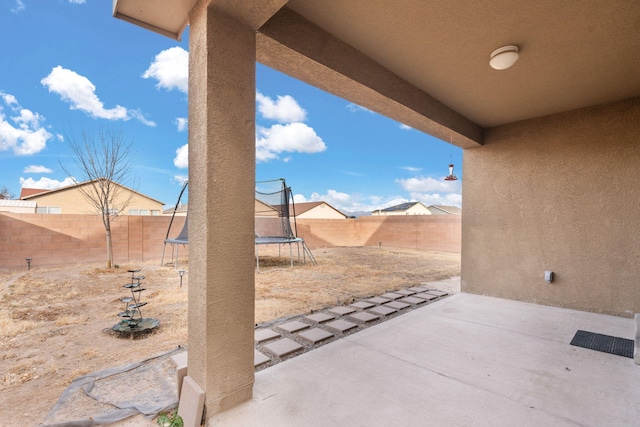 view of patio with a fenced backyard and a trampoline