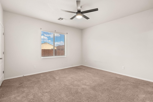 spare room featuring a ceiling fan, baseboards, visible vents, and carpet flooring