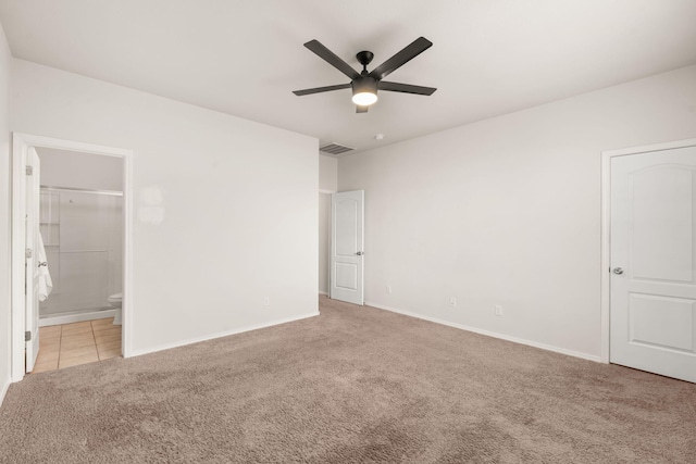 unfurnished bedroom with baseboards, visible vents, connected bathroom, light colored carpet, and ceiling fan