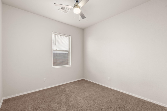 spare room featuring baseboards, carpet floors, visible vents, and a ceiling fan