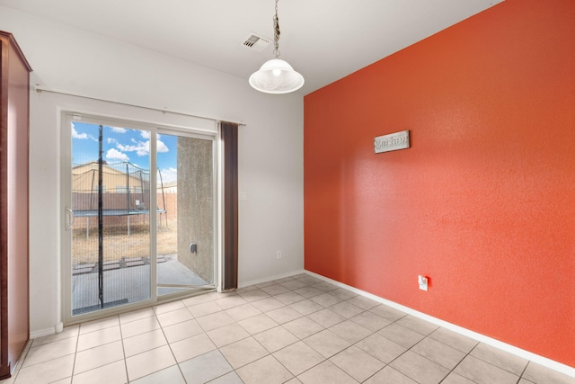 spare room with light tile patterned flooring, visible vents, and baseboards