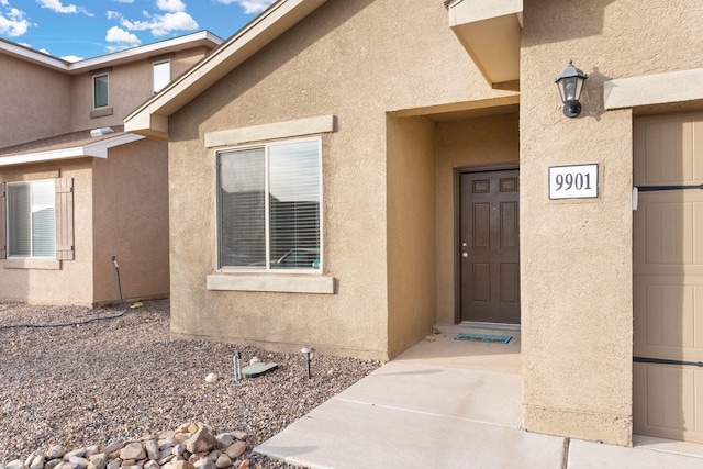 view of exterior entry featuring stucco siding