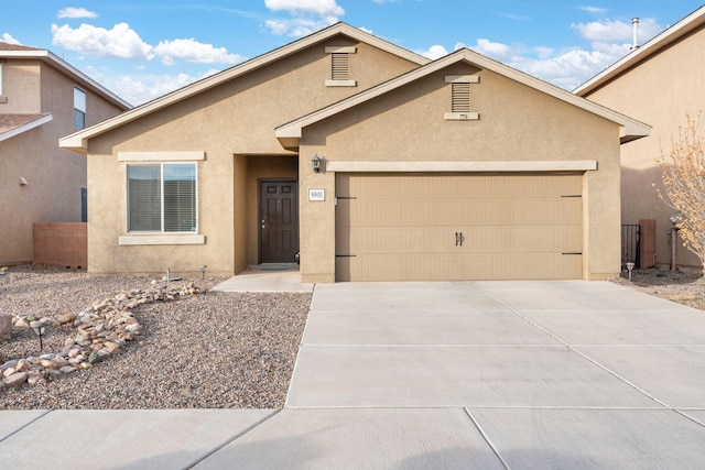 ranch-style home featuring stucco siding, concrete driveway, an attached garage, and fence