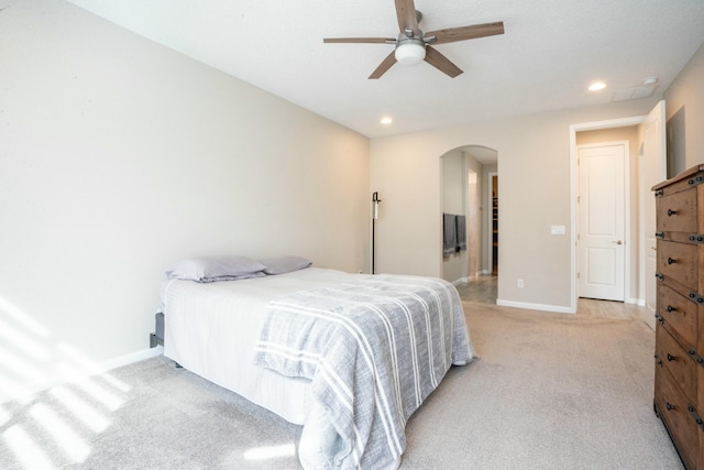 bedroom featuring arched walkways, recessed lighting, light carpet, ceiling fan, and baseboards