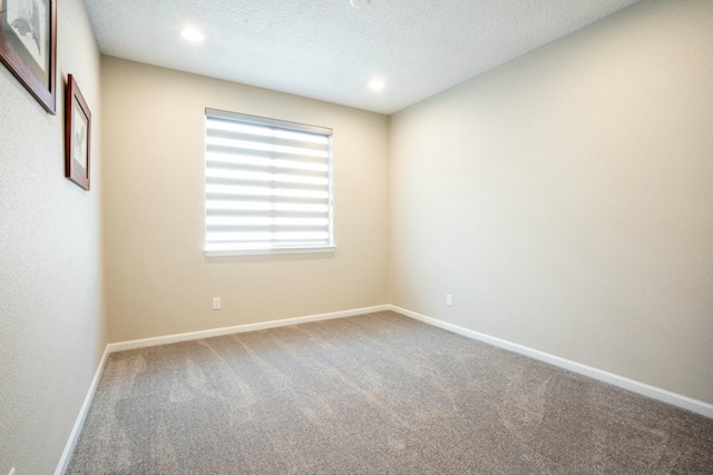 carpeted empty room featuring baseboards, a textured ceiling, and recessed lighting