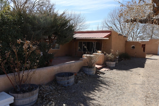 rear view of house with a standing seam roof and metal roof