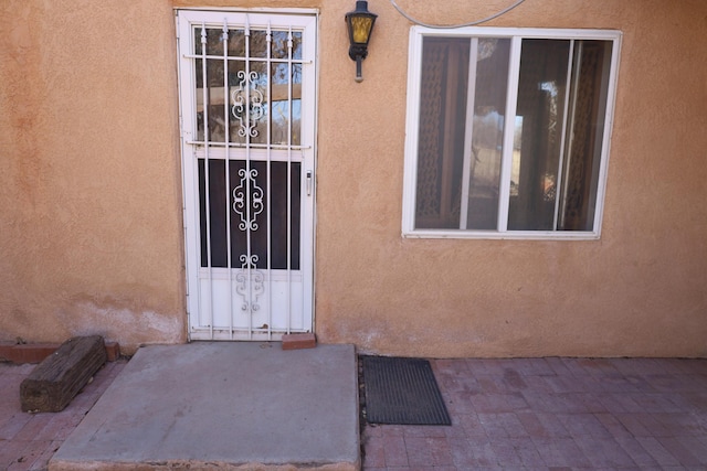 entrance to property featuring stucco siding