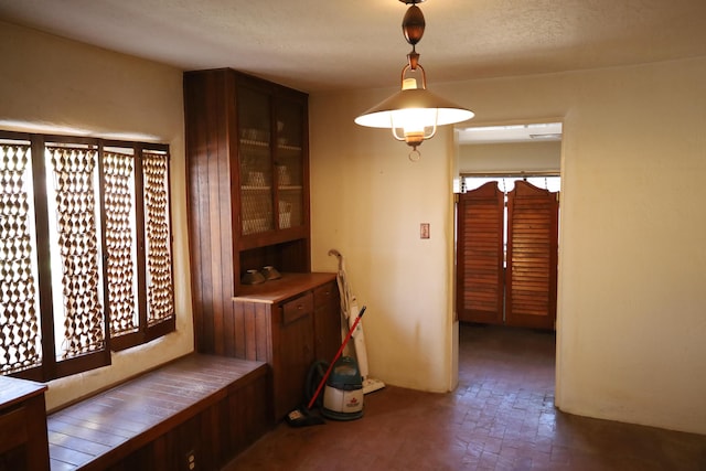 dining room featuring a textured ceiling and brick floor