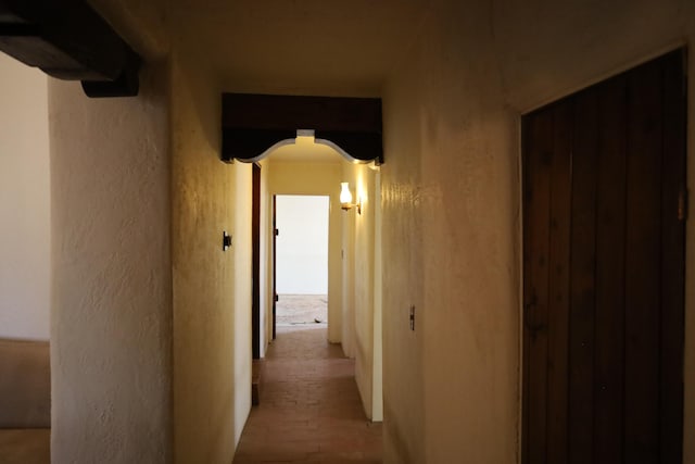 corridor with arched walkways and a textured wall