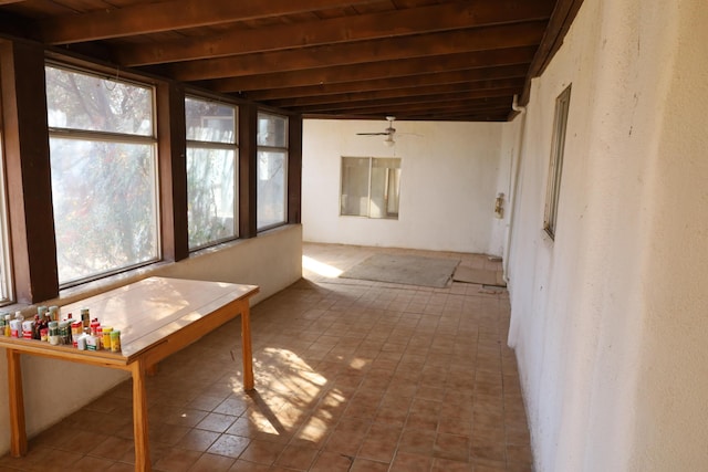 unfurnished sunroom with wood ceiling, plenty of natural light, and beam ceiling