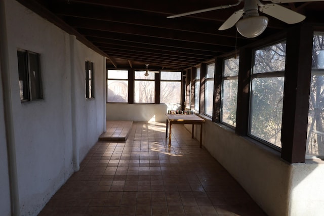 unfurnished sunroom with ceiling fan