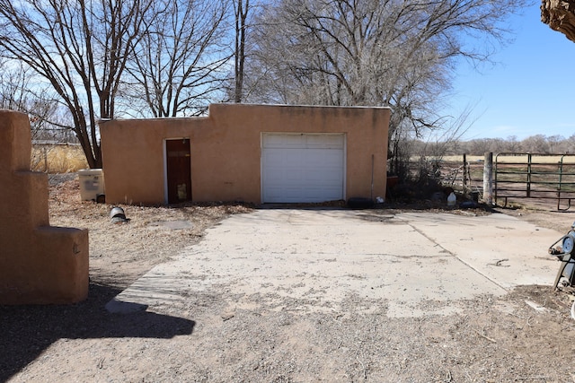 garage featuring driveway and fence