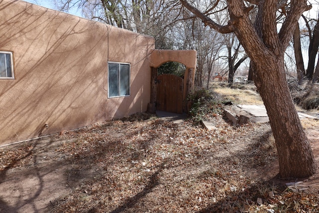 view of home's exterior featuring a gate and stucco siding