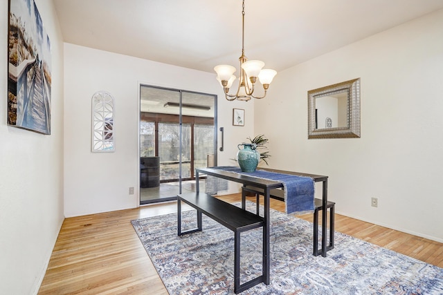 dining room featuring light wood-type flooring and an inviting chandelier