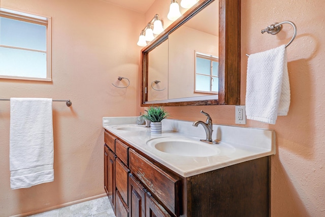 bathroom featuring double vanity, a sink, and baseboards