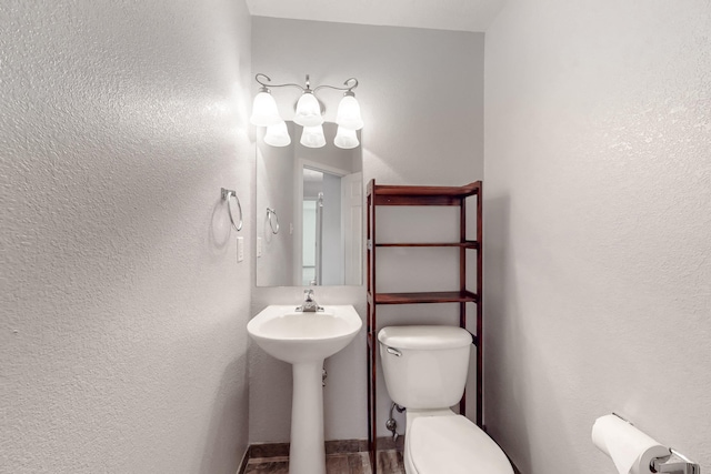 bathroom featuring a textured wall and toilet