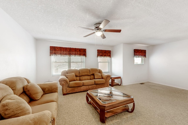 carpeted living area with visible vents, a textured ceiling, baseboards, and a ceiling fan