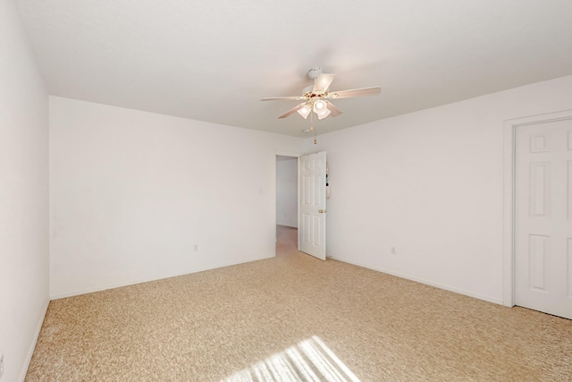 spare room with a ceiling fan and light colored carpet