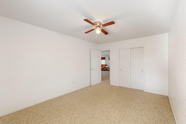 unfurnished bedroom featuring carpet floors, a closet, a ceiling fan, and baseboards