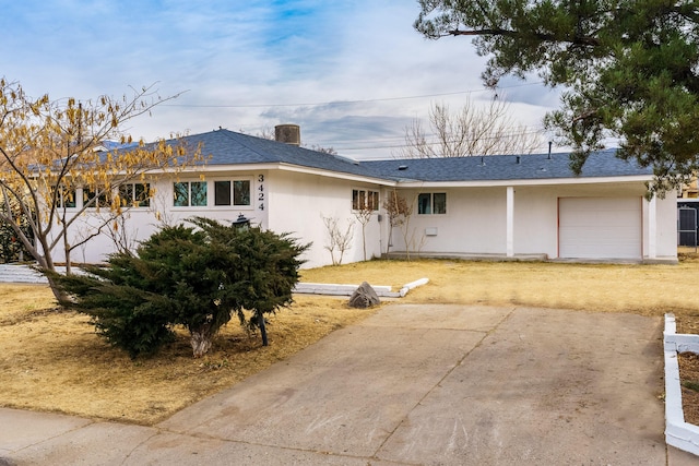 ranch-style house featuring a shingled roof, an attached garage, driveway, and stucco siding