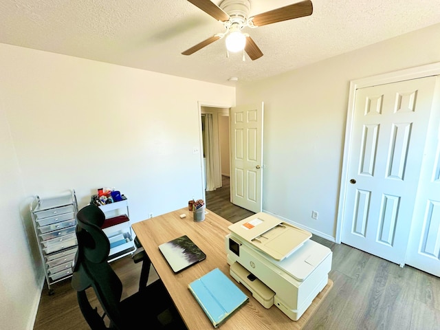 office space featuring a ceiling fan, a textured ceiling, baseboards, and dark wood-type flooring