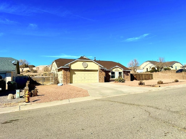 ranch-style house featuring a garage, brick siding, fence, concrete driveway, and a residential view