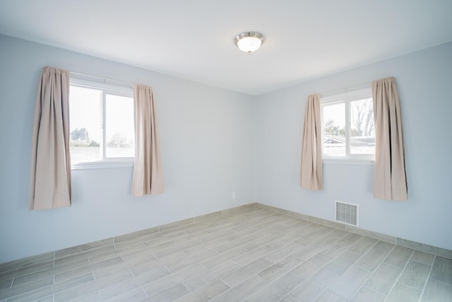 spare room featuring light wood-style flooring and visible vents