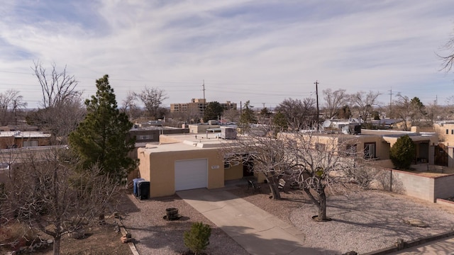 view of front of house with driveway, an attached garage, and stucco siding