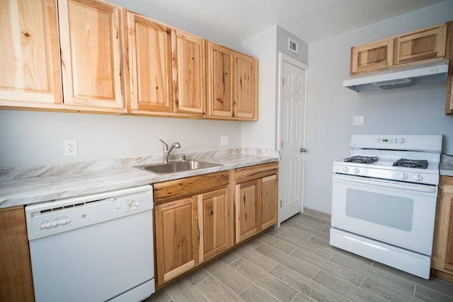 kitchen with white appliances, visible vents, light countertops, under cabinet range hood, and a sink