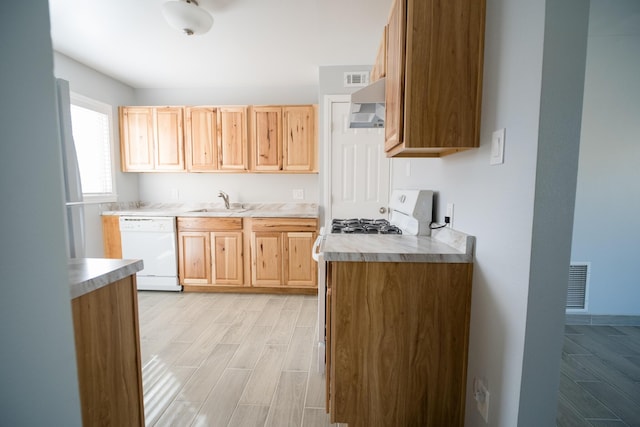 kitchen featuring wood finish floors, visible vents, light countertops, wall chimney range hood, and dishwasher