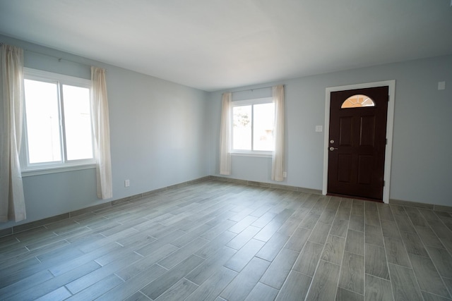 foyer entrance featuring light wood-style flooring and baseboards