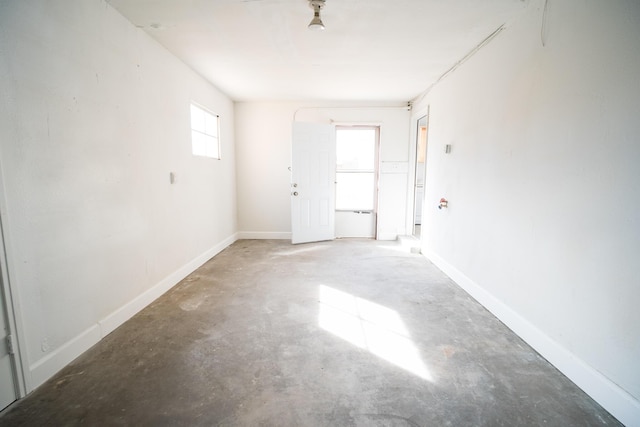 empty room featuring concrete floors and baseboards