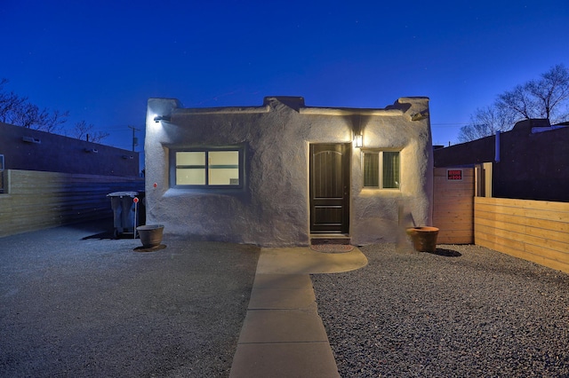 view of front facade featuring fence and stucco siding