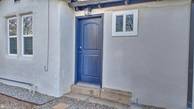 entrance to property featuring stucco siding