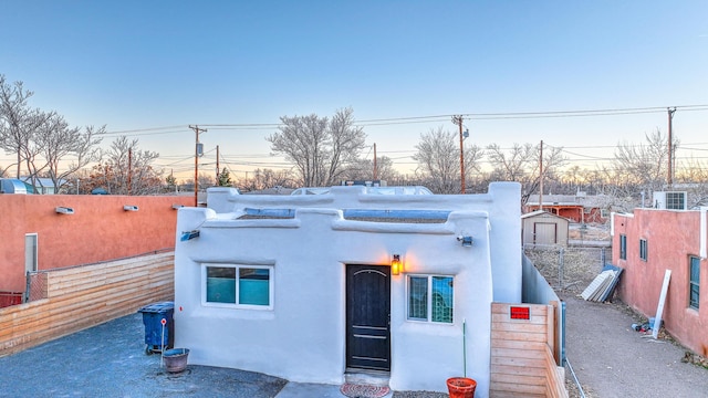 view of front of property featuring fence and stucco siding