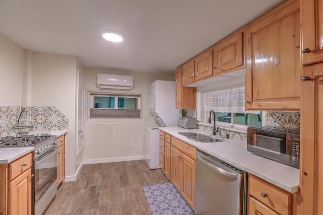 kitchen featuring stainless steel appliances, tasteful backsplash, light countertops, an AC wall unit, and a sink