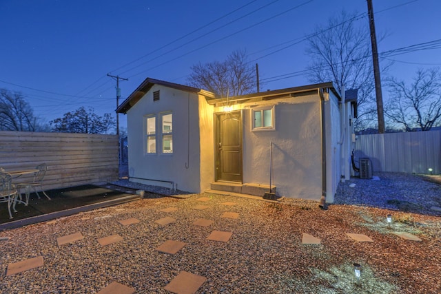 view of outbuilding featuring fence and central air condition unit