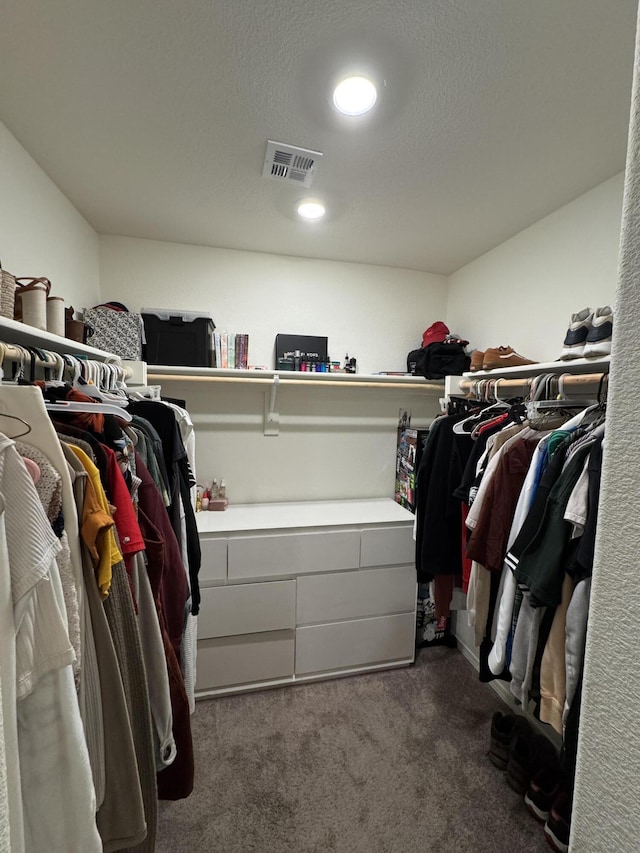 spacious closet with visible vents and dark carpet