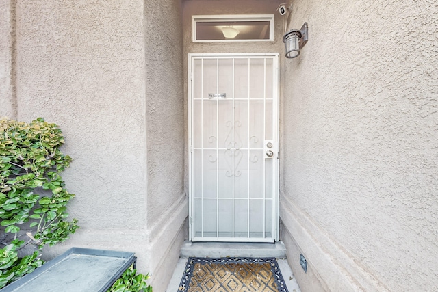 view of exterior entry featuring stucco siding